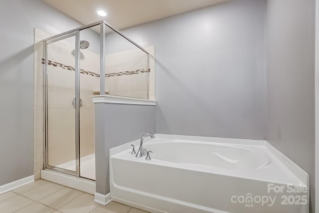 bathroom featuring tile patterned flooring and shower with separate bathtub