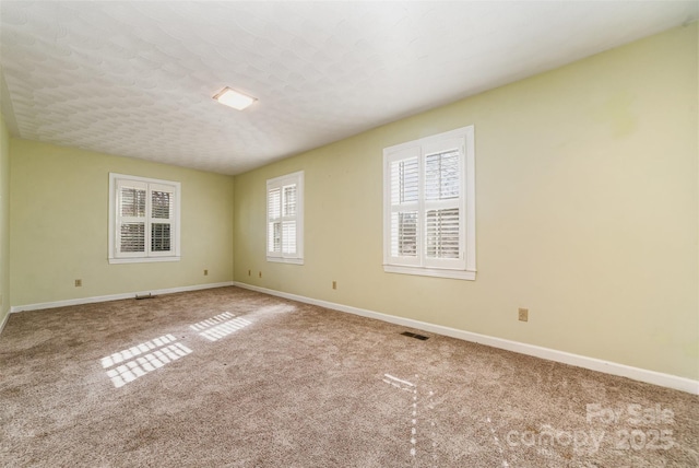 carpeted spare room with a textured ceiling