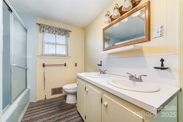 full bathroom featuring shower / bath combination with glass door, vanity, and toilet