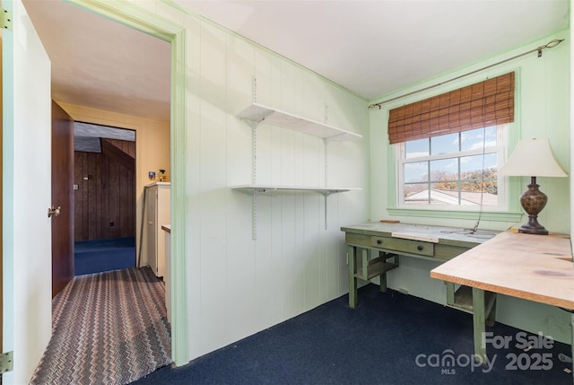 carpeted office featuring wooden walls