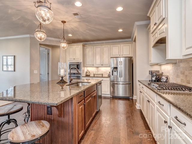 kitchen featuring stone countertops, decorative light fixtures, sink, a kitchen island with sink, and stainless steel appliances