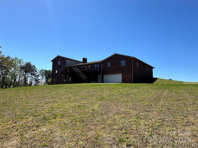 back of house with a yard and a garage