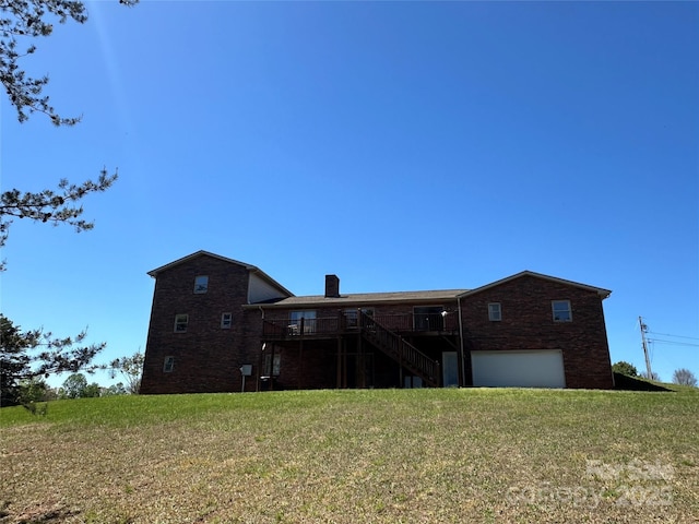 back of property featuring a lawn and a garage