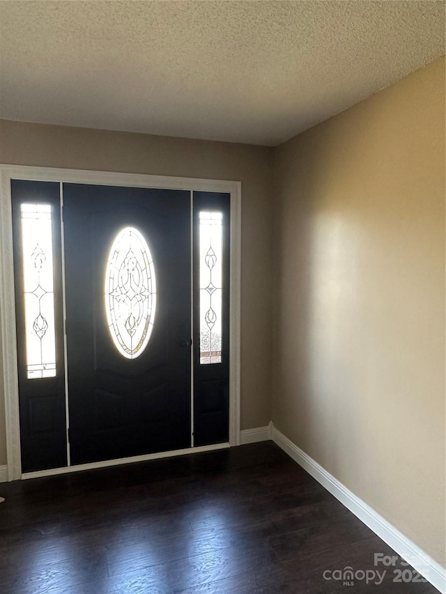 entryway with a textured ceiling and dark hardwood / wood-style floors