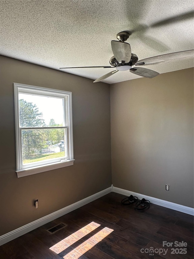 unfurnished room with a textured ceiling, ceiling fan, and dark hardwood / wood-style floors