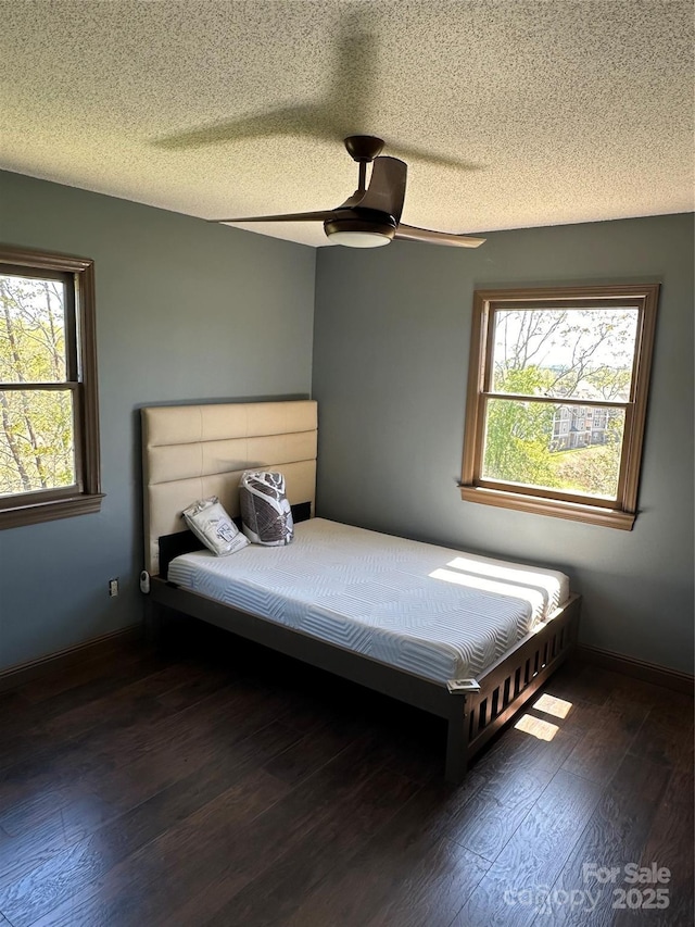 unfurnished bedroom featuring a textured ceiling, ceiling fan, and dark wood-type flooring