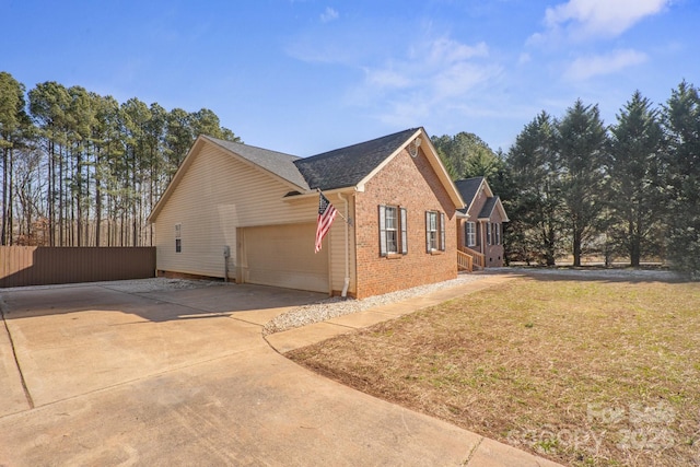 view of side of property featuring a garage and a lawn