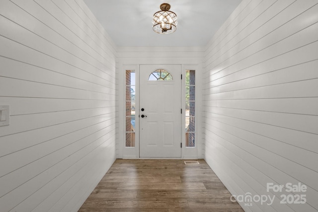 interior space featuring dark wood-type flooring and an inviting chandelier