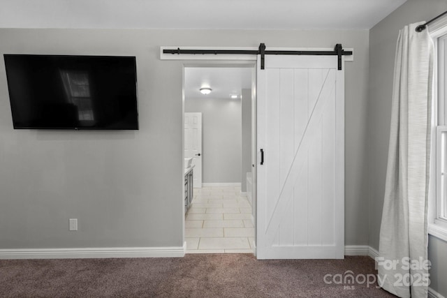 corridor with light carpet and a barn door