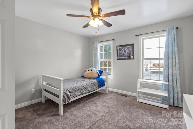 carpeted bedroom with ceiling fan and multiple windows