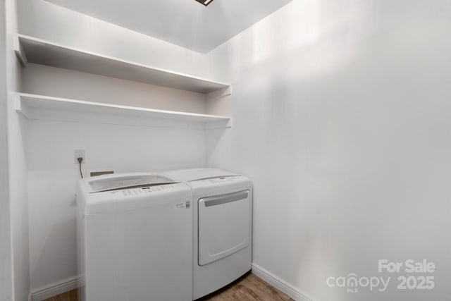 clothes washing area featuring washing machine and dryer and dark hardwood / wood-style flooring