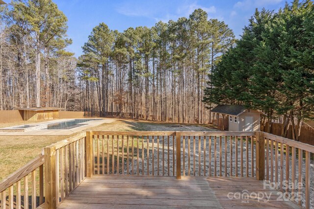 wooden terrace featuring a shed and a covered pool