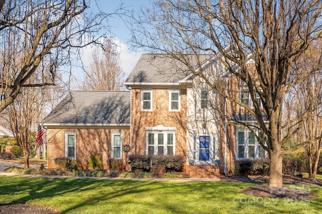 colonial inspired home with a front lawn