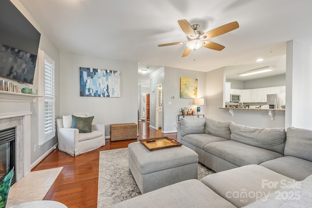 living room with a healthy amount of sunlight, ceiling fan, and wood-type flooring