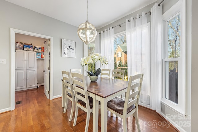 dining space featuring a wealth of natural light, hardwood / wood-style flooring, and a chandelier