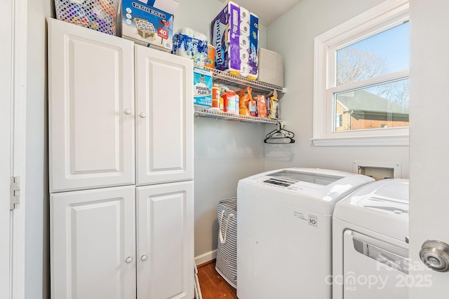 clothes washing area featuring independent washer and dryer, cabinets, and wood-type flooring