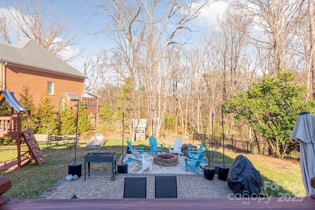 view of patio with grilling area, a playground, and a fire pit