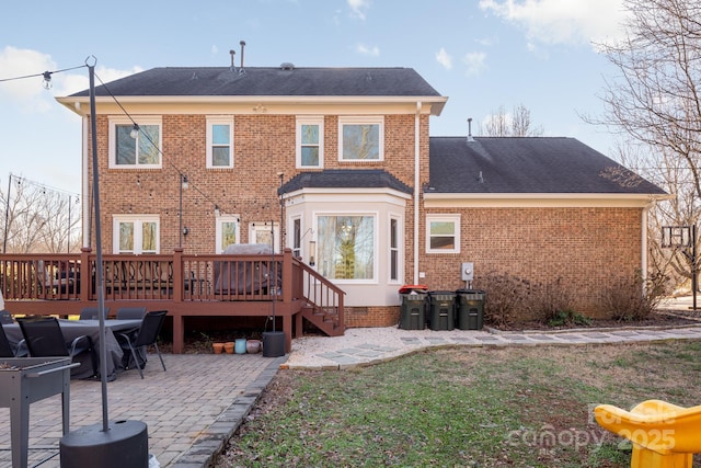 back of property with a wooden deck and a patio area