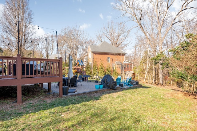 view of yard featuring a deck and a patio