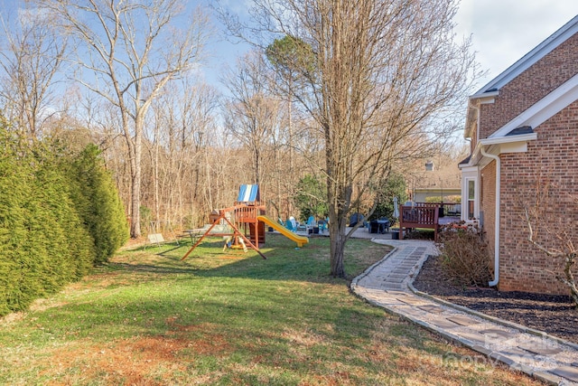 view of yard with a deck and a playground