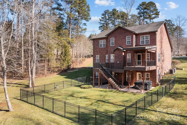 back of house with a lawn, a wooden deck, a patio area, a hot tub, and central air condition unit