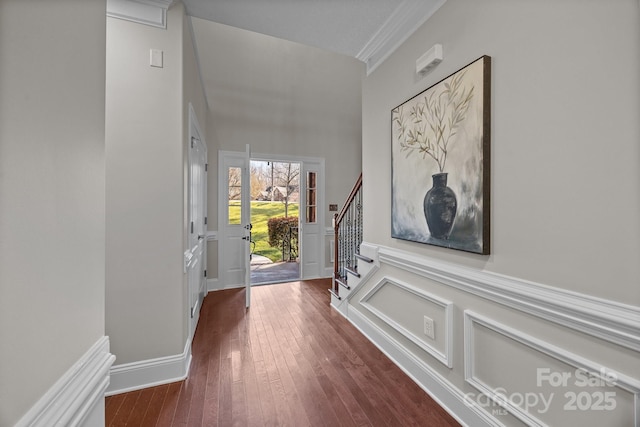 foyer with dark wood-type flooring and ornamental molding