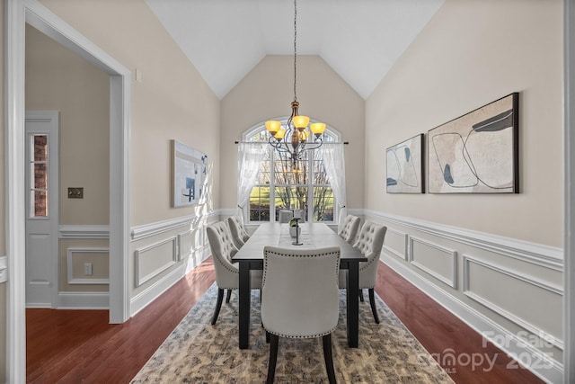 dining area featuring dark hardwood / wood-style flooring, vaulted ceiling, and a notable chandelier