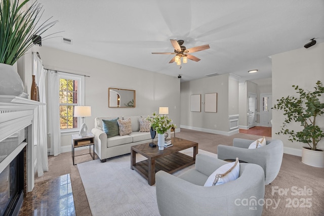 living room with ceiling fan and a fireplace