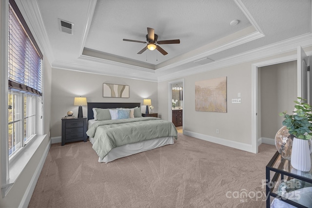 bedroom featuring crown molding, ensuite bathroom, a raised ceiling, and light carpet