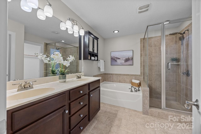 bathroom with independent shower and bath, vanity, and a textured ceiling