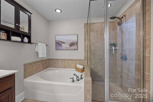 bathroom with vanity, plus walk in shower, and a textured ceiling