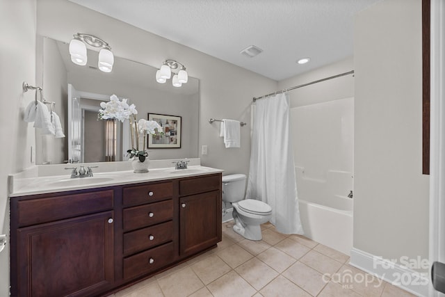 full bathroom with shower / tub combo with curtain, vanity, toilet, tile patterned floors, and a textured ceiling