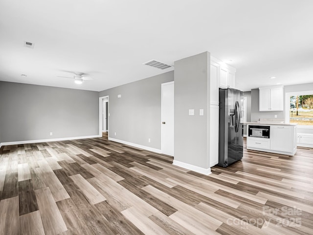 unfurnished living room featuring ceiling fan and light hardwood / wood-style flooring