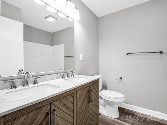 bathroom with wood-type flooring, toilet, and vanity