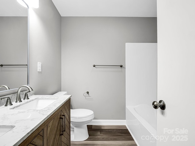 bathroom with vanity, toilet, and hardwood / wood-style flooring