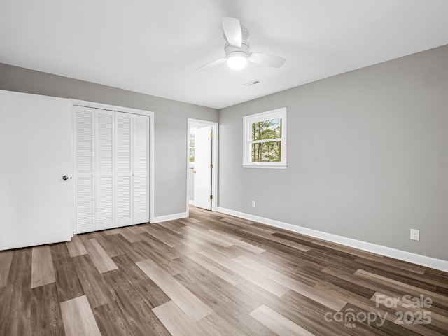 unfurnished bedroom with ceiling fan, a closet, and light hardwood / wood-style flooring