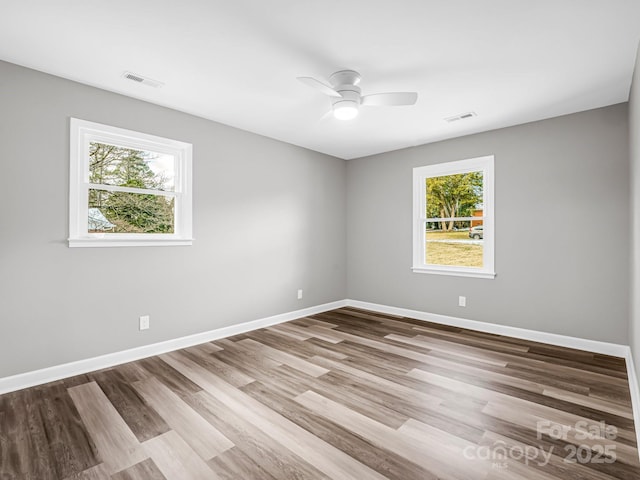 empty room featuring ceiling fan, light hardwood / wood-style flooring, and a wealth of natural light