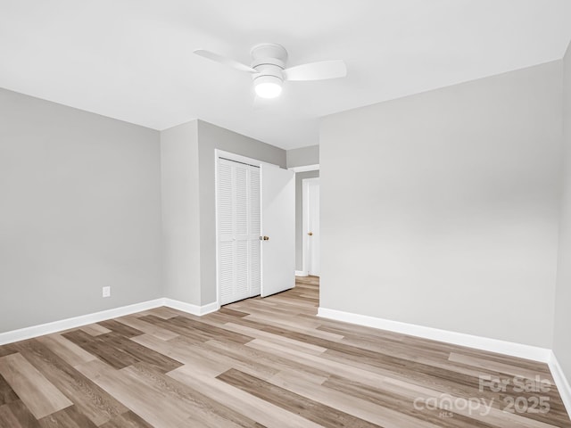 empty room with ceiling fan and light hardwood / wood-style flooring