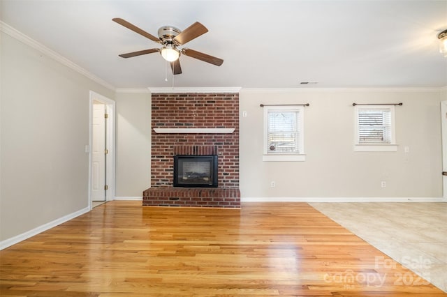 unfurnished living room featuring ceiling fan, a fireplace, crown molding, and light hardwood / wood-style flooring