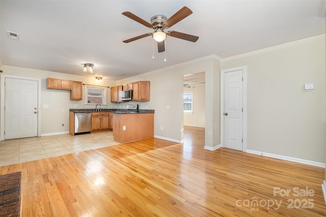 kitchen featuring appliances with stainless steel finishes, light hardwood / wood-style floors, sink, ornamental molding, and ceiling fan