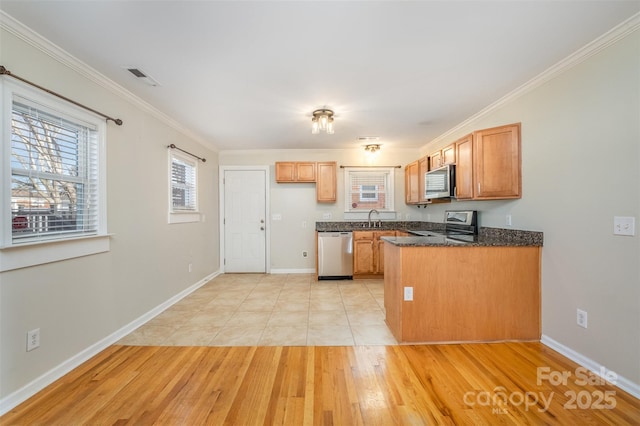 kitchen with light wood-type flooring, stainless steel appliances, crown molding, and sink