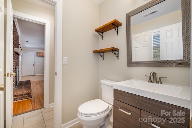 bathroom with toilet, vanity, and tile patterned floors