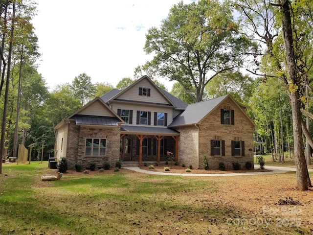 craftsman inspired home featuring a porch, brick siding, and a front lawn