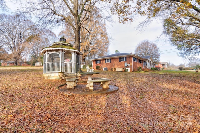 view of yard featuring a gazebo and a sunroom