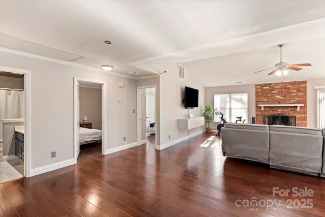 living room with ceiling fan, lofted ceiling, a brick fireplace, and dark wood-type flooring