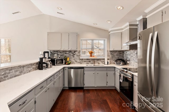 kitchen featuring lofted ceiling, sink, appliances with stainless steel finishes, gray cabinetry, and dark hardwood / wood-style flooring