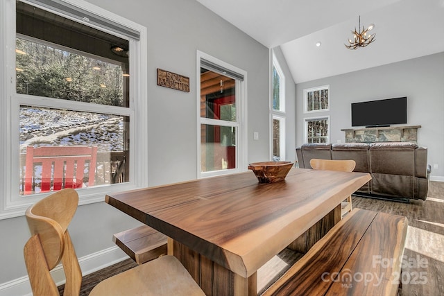 dining room featuring wood-type flooring, lofted ceiling, and an inviting chandelier