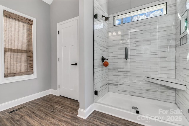 bathroom featuring hardwood / wood-style flooring and a shower with door