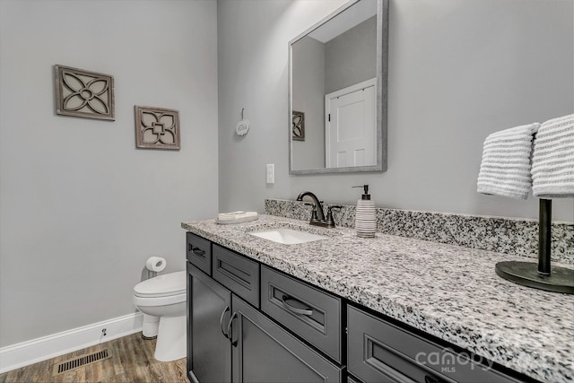 bathroom with toilet, hardwood / wood-style flooring, and vanity