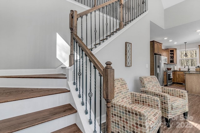 staircase featuring sink and wood-type flooring